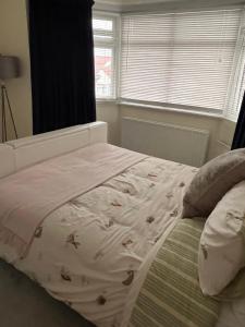 a bed in a bedroom with a blanket on it at Home from Home Cosy B&B in London