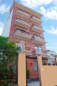 um edifício alto de tijolos vermelhos com varandas em Madhuban Hotel em Catmandu