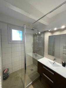 uma casa de banho com uma cabina de duche em vidro e um lavatório. em Apt neuf à 1 min de la mer à Sausset em Sausset-les-Pins