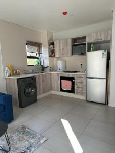 a kitchen with a white refrigerator and a stove at The Abode in Gaborone