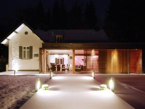 une maison éclairée dans la cour la nuit dans l'établissement Plushy Holiday Home in Spa with bubble bath Pool, à Spa