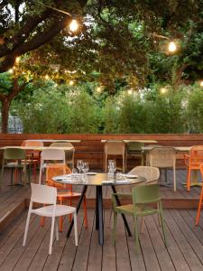 a patio with tables and chairs on a deck at Re Versiliana Hotel in Marina di Pietrasanta