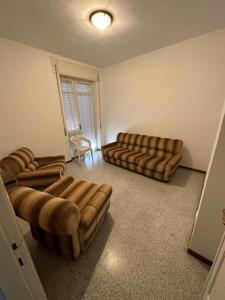 uma sala de estar com dois sofás e uma cadeira em APPARTAMENTO GYNKgO em Ponte San Giovanni