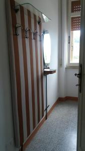 - une salle de bains avec un mur rayé et un miroir dans l'établissement APPARTAMENTO GYNKgO, à Ponte San Giovanni