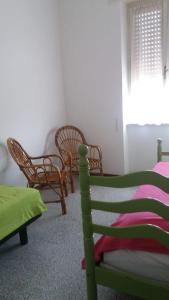 - une chambre avec un lit, des chaises et une fenêtre dans l'établissement APPARTAMENTO GYNKgO, à Ponte San Giovanni