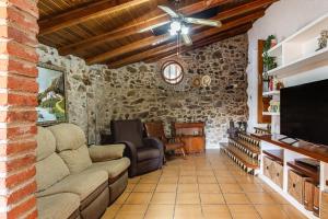a living room with a couch and a tv at Masia Can Vilar in Maçanet de la Selva