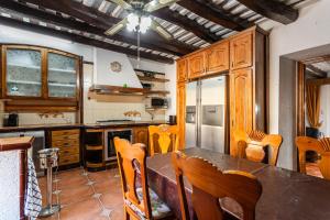 a kitchen with wooden cabinets and a table and chairs at Masia Can Vilar in Maçanet de la Selva