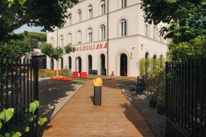 a building with a wooden walkway in front of it at Re Versiliana Hotel in Marina di Pietrasanta