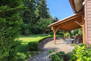 a patio with a table and chairs under a pavilion at Harzhaus Romantica in Hahnenklee-Bockswiese