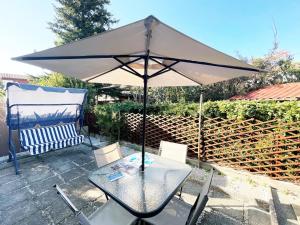 a table with an umbrella on a patio at Bagnaia Lido 16 - ArgonautiVacanze in Portoferraio