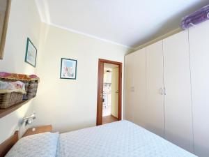 a white bedroom with a bed and a closet at Bagnaia Lido 16 - ArgonautiVacanze in Portoferraio