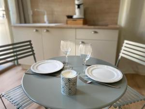 a table with two plates and glasses on it at La chambre de Madeleine in Commercy