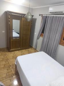 a bedroom with a white bed and a mirror at Azazi house in Quseir