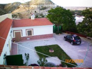 ein Auto, das auf einem Parkplatz neben einem Haus geparkt ist in der Unterkunft Casa Cueva Maite in Cortes de Baza