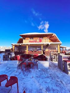 a building with a table and chairs in the snow at Berggasthof Platzlalm in Kaltenbach