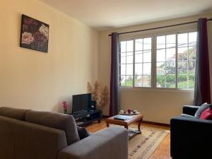 ein Wohnzimmer mit einem Sofa und einem TV in der Unterkunft Vigário House in Câmara de Lobos