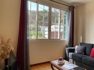 ein Wohnzimmer mit einem Sofa und einem Fenster in der Unterkunft Vigário House in Câmara de Lobos