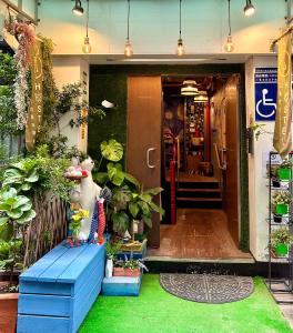Zugang zu einem Laden mit Pflanzen und einer blauen Bank in der Unterkunft Taipei Triple Tiger Inn in Taipeh