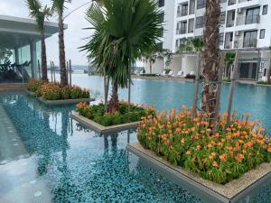 a swimming pool with flowers and palm trees in a building at SY@Tiara Homestay in Bangi