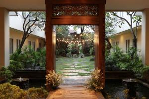 an entrance to a garden with a wooden pathway at Bale Ocasa in Tangerang