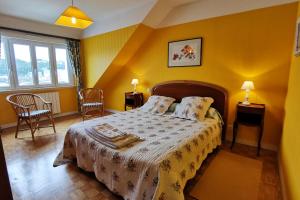 - une chambre avec un lit aux murs jaunes dans l'établissement Mer de Vent, à Audierne