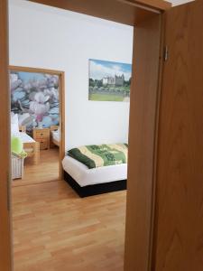 - une chambre avec un lit et une peinture murale dans l'établissement Ferienwohnung am Viaduktweg Familie Roman, à Langenleuba-Niederhain