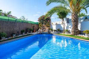 una piscina con palmeras en una casa en Traditional Villa, en Creixell