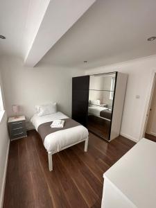 um quarto com uma cama e um espelho grande em Barbican Pad by condokeeper em Londres