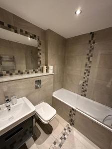 uma casa de banho com um lavatório, um WC e uma banheira em Barbican Pad by condokeeper em Londres
