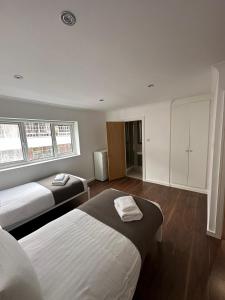 um quarto de hotel com duas camas e uma cozinha em Barbican Pad by condokeeper em Londres