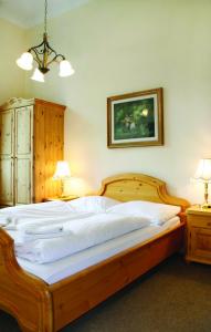 uma grande cama de madeira num quarto com 2 candeeiros em Schloss Schmuggerow em Schmuggerow