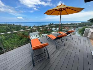 a balcony with chairs and an umbrella on a deck at Tropical Villa 1 in Lamai