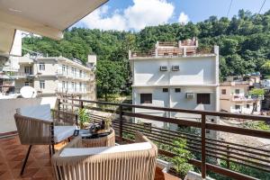 een balkon met een tafel en stoelen en uitzicht bij Homlee - Hill View Apartment Luxury in Rishīkesh