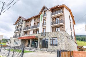 巴库里阿尼Hotel 25 Bakuriani的一座大型石头建筑,设有窗户和阳台