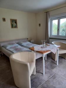 a room with two beds and a table and chairs at Villa Romy mit 3 Gästezimmer in Bad Ischl