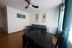 uma sala de jantar com uma mesa e cadeiras e um sofá em Confortevole appartamento playa del ingles em Maspalomas