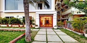 a building with a red door and a palm tree at De Crown Luxury Hotel in Kākināda