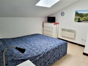 a bedroom with a bed and a dresser and a window at 2 pièces au pied des pistes in Guillaumes