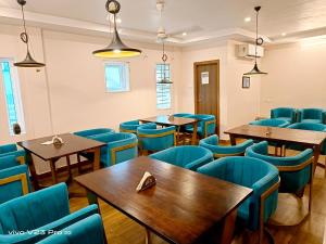 ein Restaurant mit Holztischen und blauen Stühlen in der Unterkunft De Crown Luxury Hotel in Kakinada