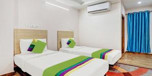 2 Betten in einem Hotelzimmer mit Regenbogen in der Unterkunft De Crown Luxury Hotel in Kakinada