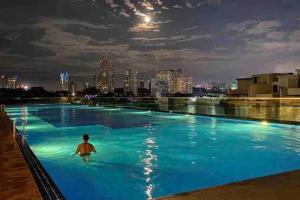 un hombre en una piscina por la noche en Paragon Seaview 30th Floor【2BR Near CIQ】Netflix, en Johor Bahru