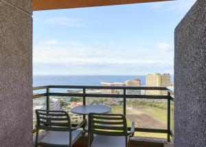un balcón con 2 sillas, una mesa y el océano en AluaSoul Orotava Valley - Adults Only, en Puerto de la Cruz