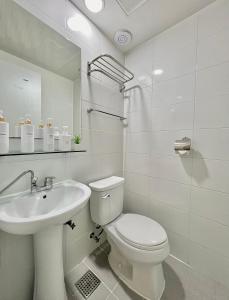 Baño blanco con aseo y lavamanos en Seoul Grand Hostel EWHA Univ en Seúl