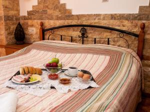 - un plateau de petit-déjeuner avec des fruits sur un lit dans l'établissement Astromeria, à Makrirrákhi