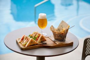 Una mesa con un vaso de cerveza y un plato de comida. en AluaSoul Orotava Valley - Adults Only, en Puerto de la Cruz