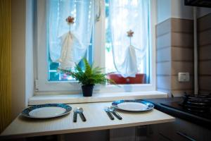 a kitchen counter with two plates and a window at Nice place in Drumul Taberei in Bucharest