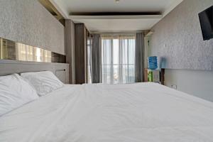 een groot wit bed in een kamer met een raam bij OYO Life 93097 Apartemen Gateway Pasteur By Kaisar Room in Bandung