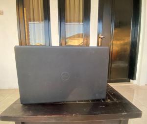 a laptop computer sitting on a table in front of a door at OYO Life 93154 White Kos Jenggala in Tanjung