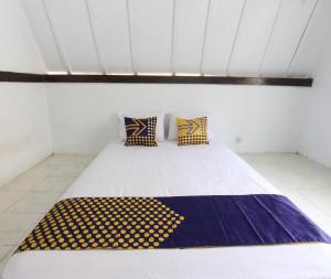 ein Schlafzimmer mit einem großen Bett in einem Zimmer in der Unterkunft OYO Life 93154 White Kos Jenggala in Tanjung