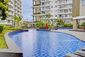 a swimming pool in front of a building at OYO Life 93065 Apartemen Gateway Pasteur By Glory Rent in Bandung